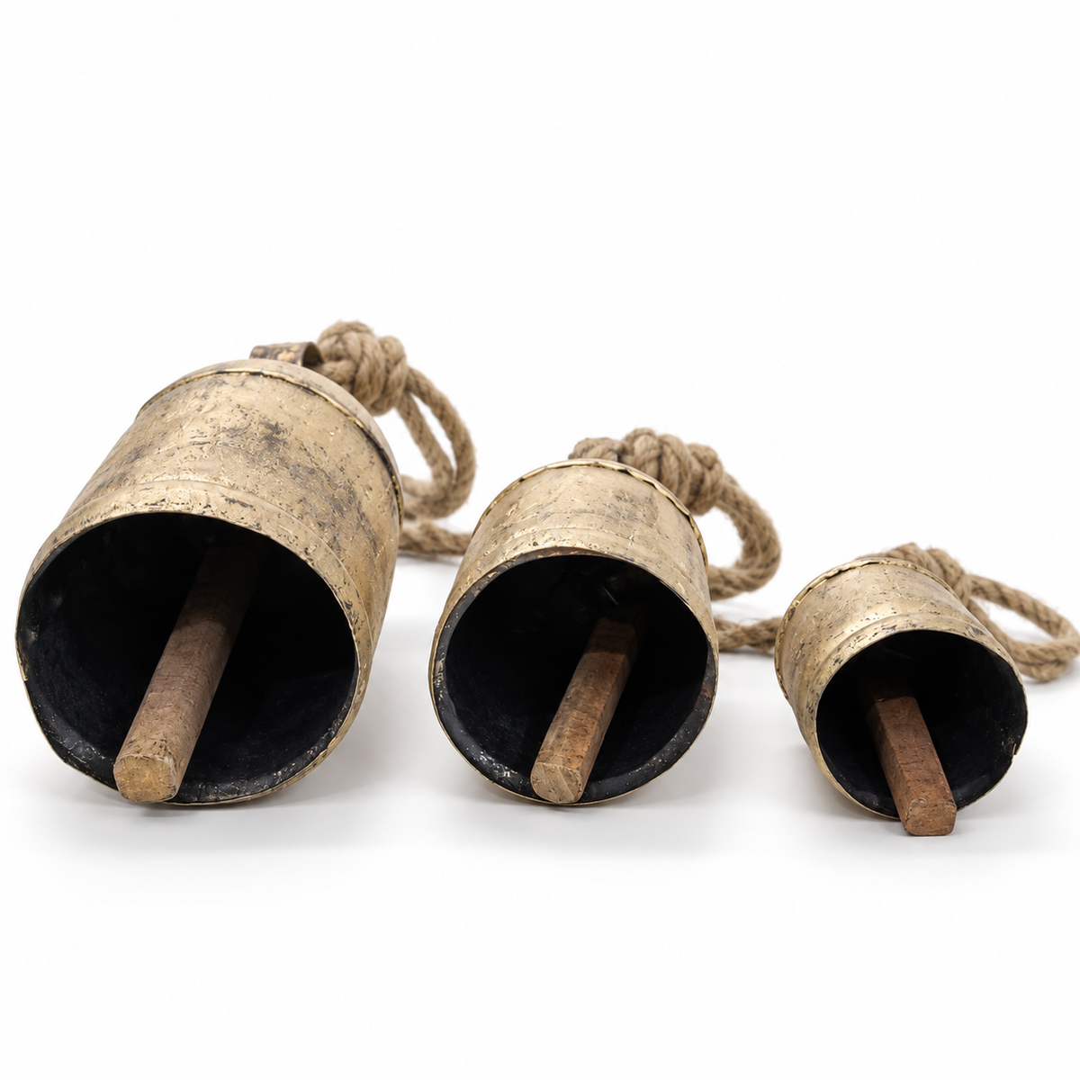 Three rustic iron bells showing their wooden clappers and jute ropes
